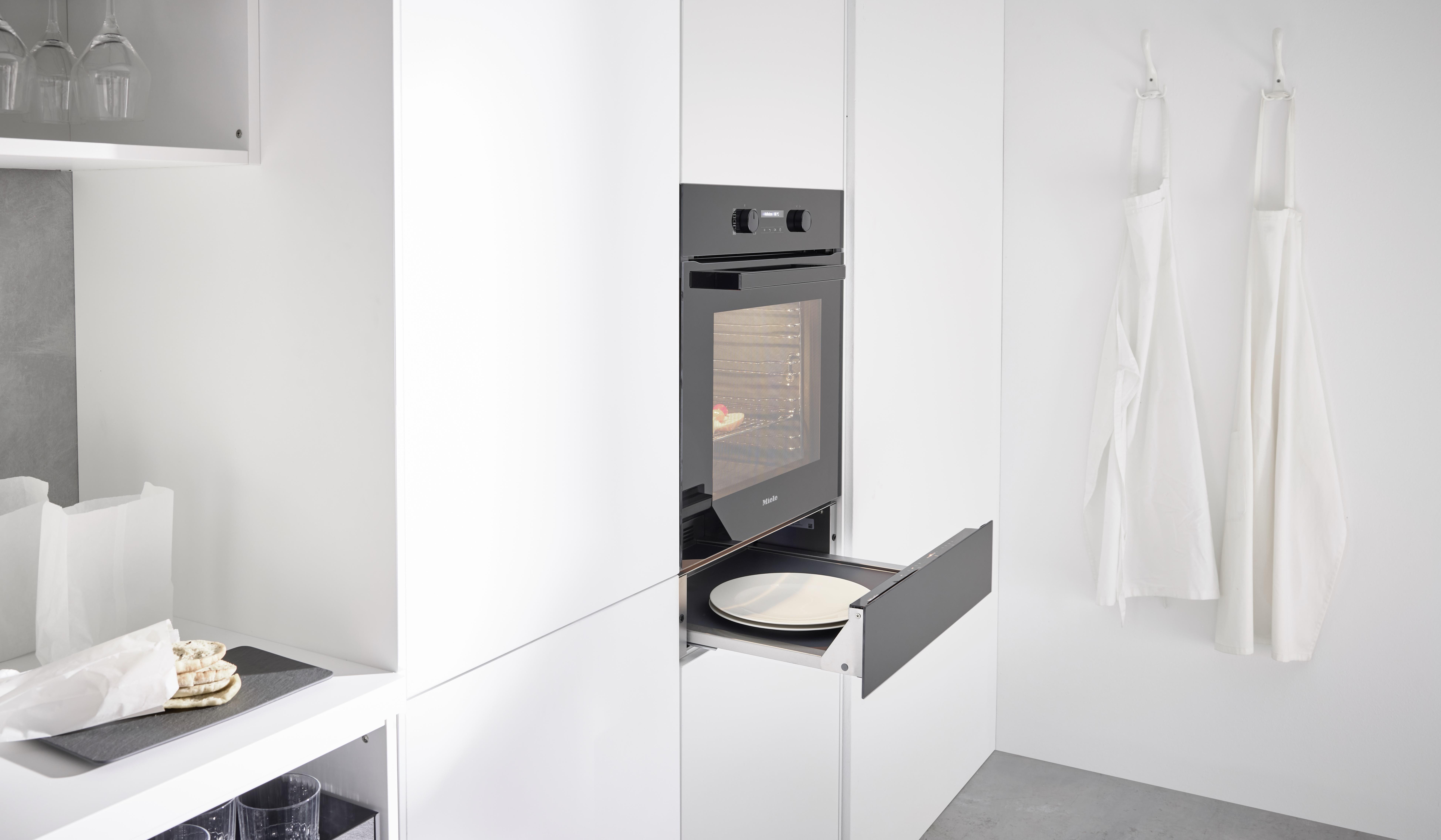 NOBILIA Alpinweiß mit Miele Geräten - Fokus auf Backofen mit Wärmeschublade geöffnet, Drehknöpfe und digitale Anzeige